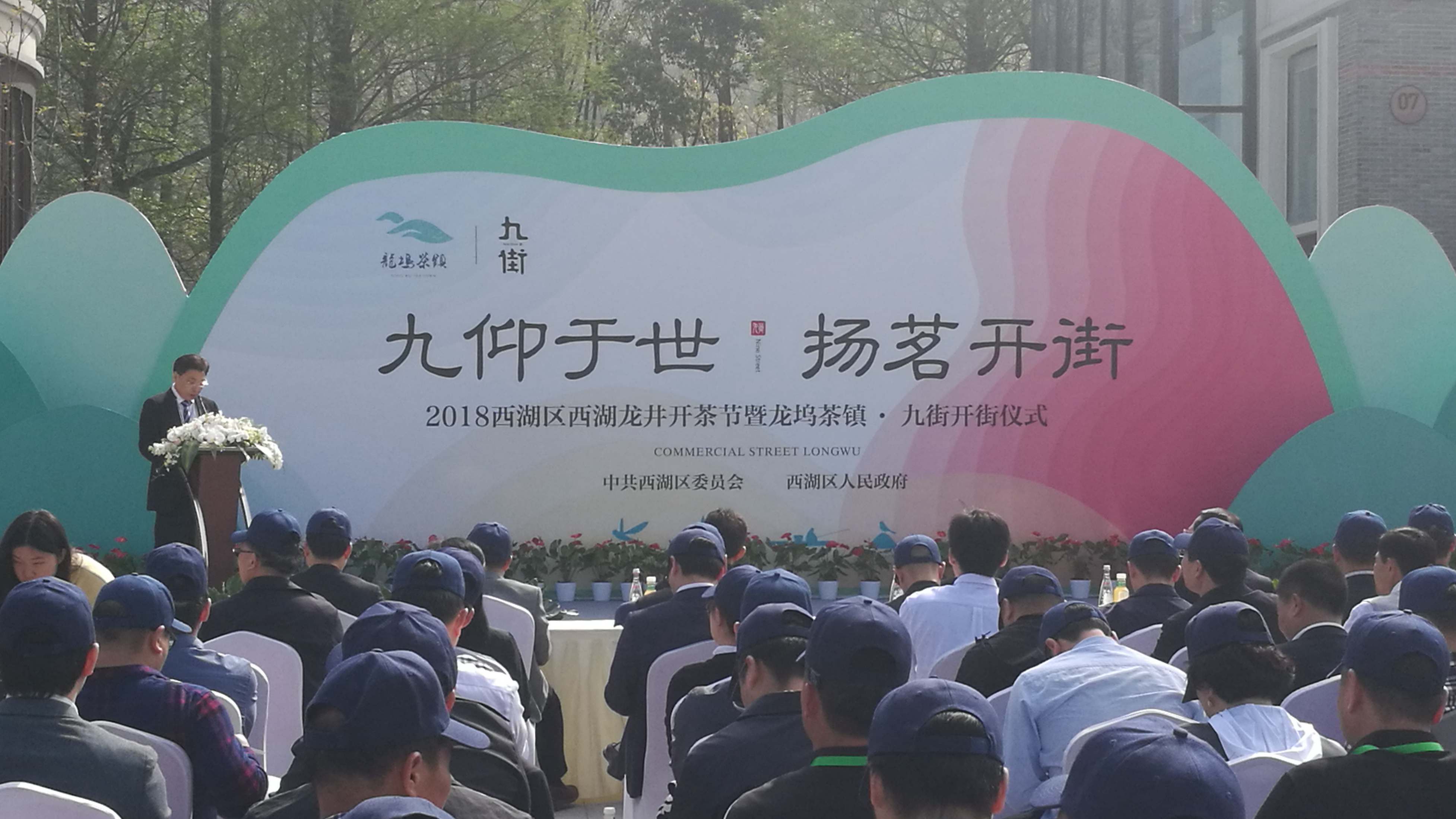 华亿(中国)一站式服务平台作为商家代表在“龙坞茶镇·九街”开街仪式上发言